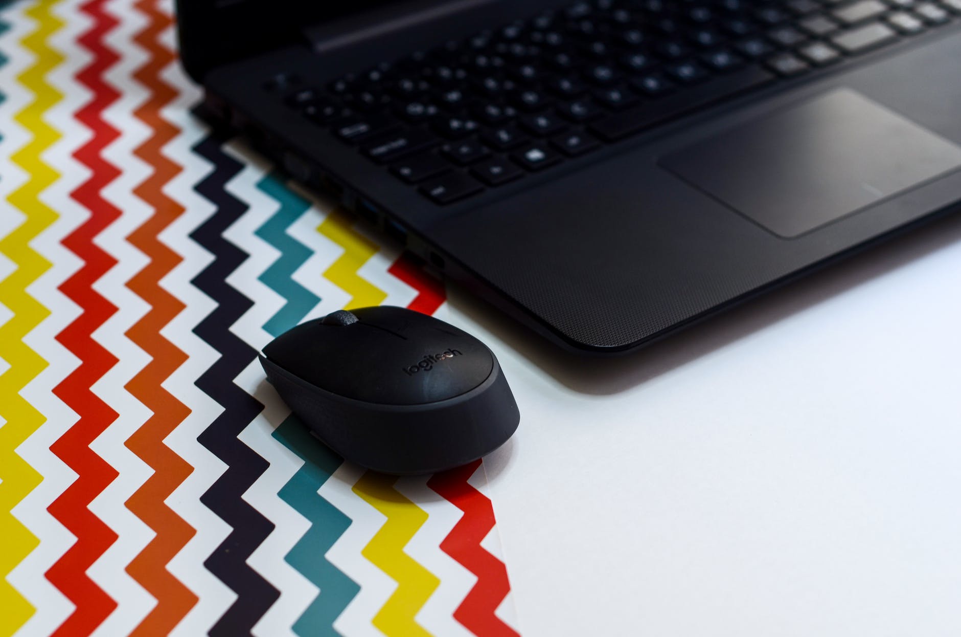 black wireless mouse beside laptop